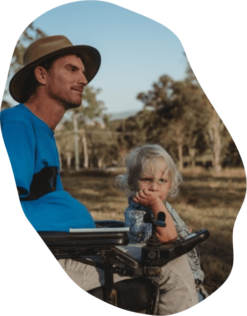 Man using a wheelchair spending time with his son outdoors.